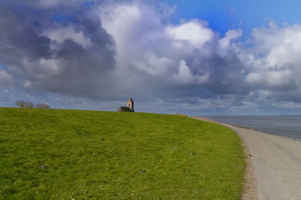 Groene dijk onder een wolkenlucht